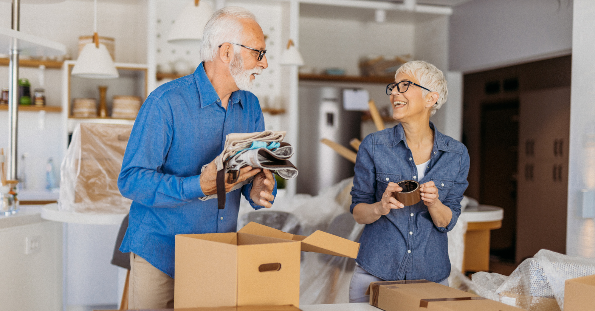 An elder couple moving belongings into boxes